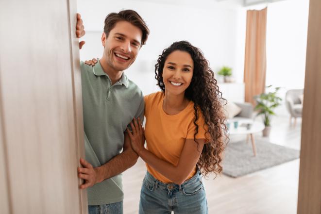 happy couple smiling after opening their front door